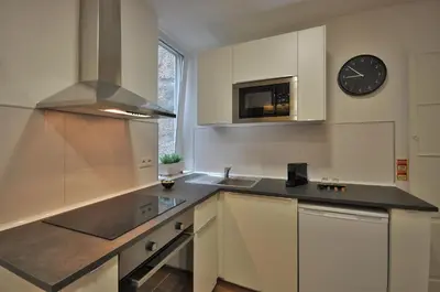 a kitchen with a sink and a clock on the wall at Casa da Ana - Porto Velho Apt in Porto