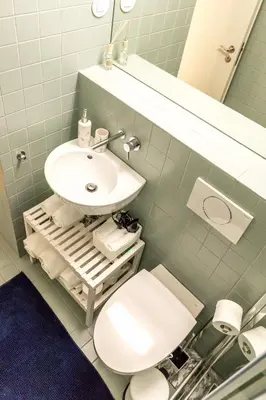 a bathroom with a sink and a toilet and a mirror at Vitoria Studio Residence - Downtown in Porto