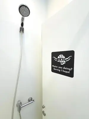 a sign on the door of a shower in a bathroom at Rivoli Cinema Hostel in Porto