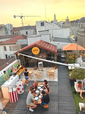 a group of people sitting at tables on a roof at Rivoli Cinema Hostel in Porto