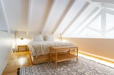 a bedroom with a bed and a large window at Casulo Loft - Oporto Downtown in Porto
