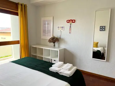 a room with a bed with towels and a mirror at Boavista YourHome in Porto