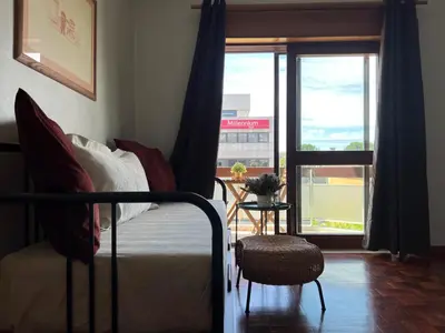 a bedroom with a bed with yellow and green sheets and a window at Boavista YourHome in Porto