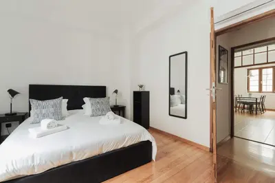 a bedroom with a large bed and a dining room at Puro Apartment in Porto