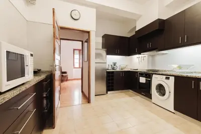 a kitchen with a microwave and a washer and dryer at Puro Apartment in Porto