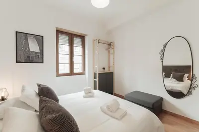 a bedroom with a white bed and a mirror at Puro Apartment in Porto