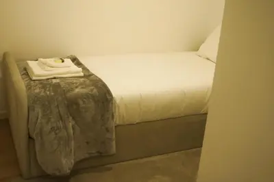 a small bedroom with a bed with a towel on it at Nightingale Apartments in Porto