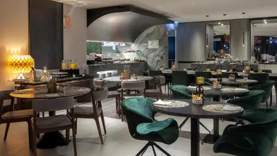 a dining room with tables and chairs and a restaurant at Porto Royal Bridges Hotel in Porto