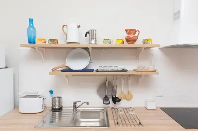 a kitchen with a sink and wooden shelves on the wall at Porto Haven - Vintage Apartment in Downtown in Porto