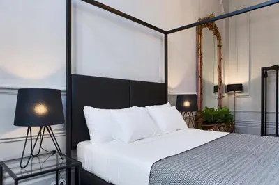 a bedroom with a white bed with a black headboard at Oporto Royal Apartment - Solar da Avenida in Porto