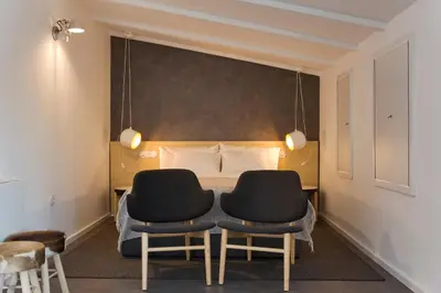 a bedroom with two chairs in front of a bed at Oporto Avenue Attic - Solar da Avenida in Porto
