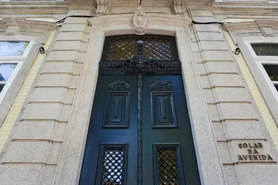 a blue door in a stone building at Oporto Avenue Attic - Solar da Avenida in Porto