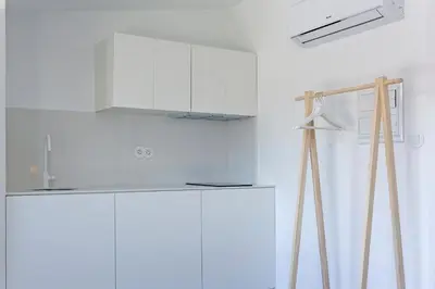 a white kitchen with a refrigerator and a hood at Oporto Avenue Attic - Solar da Avenida in Porto