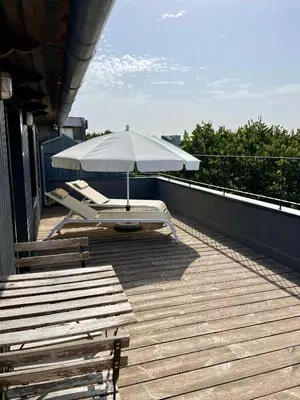 a patio with an umbrella and chairs on a roof at Oporto Avenue Attic - Solar da Avenida in Porto