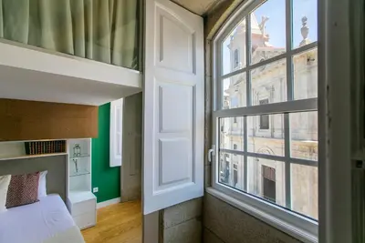 a bedroom with a bed and a large window at Casa da Cordoaria by Oporto Soul in Porto