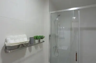 a bathroom with a shower and a shelf with towels at Oporto Memory Houses 7 in Porto