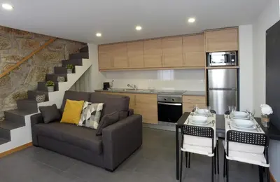 a living room with a couch and a table and a kitchen at Oporto Memory Houses 7 in Porto