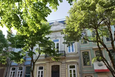 a large building with trees in front of it at Oporto Cozy Design Studio - Solar da Avenida in Porto