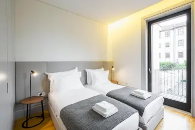 two beds in a room with a window at Thomaz Palace in Porto