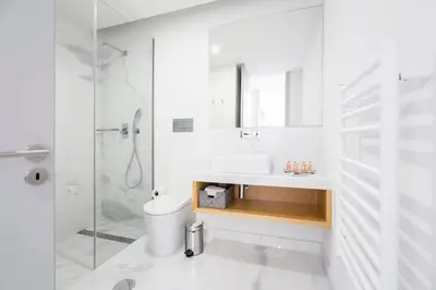 a white bathroom with a sink and a shower at Thomaz Palace in Porto