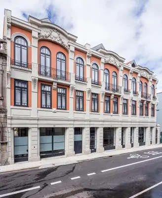 an orange and white building with windows on a street at Thomaz Palace in Porto