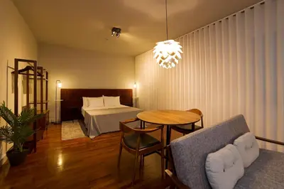 a hotel room with a bed and a table and a couch at Oporto Cozy Design Studio II - Solar da Avenida in Porto