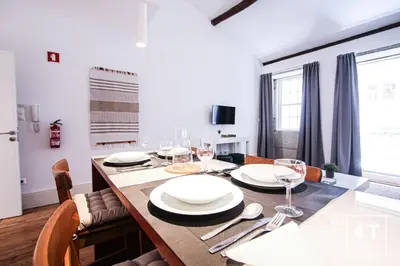 a dining room with a table with plates and wine glasses at Calacatta Housing in Porto