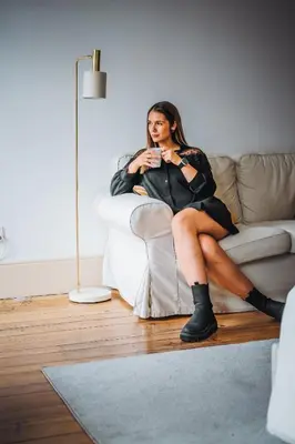 a woman in a black dress sitting on a couch at Calacatta Housing in Porto