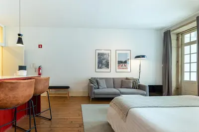 a hotel room with a bed and a couch at Calacatta Housing in Porto