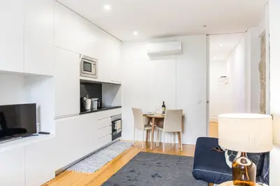 a living room with white walls and a table at Citybreak-Apartments Poveiros in Porto