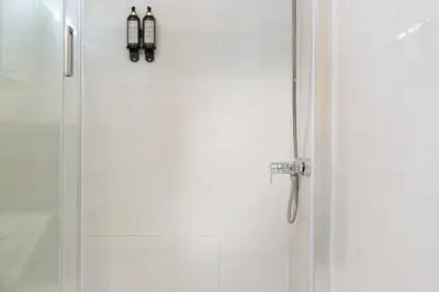 a shower with a glass door in a bathroom at Republica Deluxe Apartment in Vila Nova de Gaia