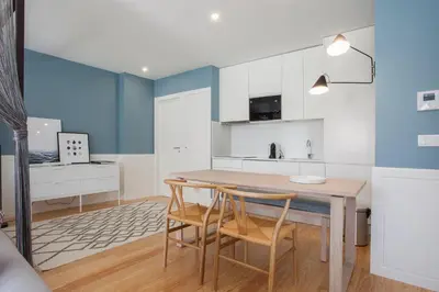 a kitchen and dining room with a table and chairs at Liiiving in Porto | Downtown Luxury Studio in Porto