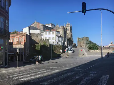 an empty city street with a traffic light and buildings at Casa da Catedral II in Porto