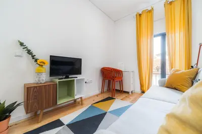 a living room with a couch and a tv at Nomad's Netto & Subway in Porto
