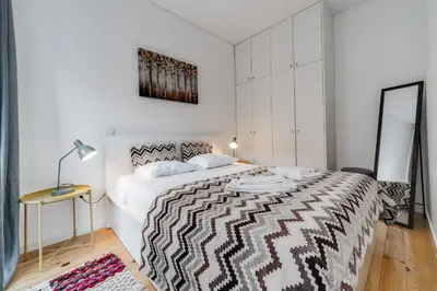 a bedroom with a bed with a black and white comforter at Nomad's Netto & Subway in Porto