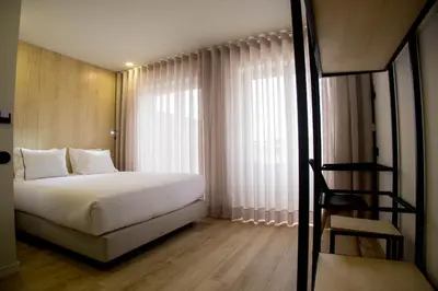 a bedroom with a white bed and a ladder to a window at The Gate Porto in Porto