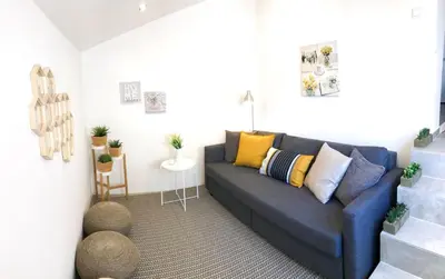 a living room with a blue couch with colorful pillows at Porto Luxury Apartments in Vila Nova de Gaia