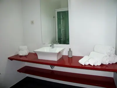 a bathroom with a red counter with a sink and towels at 12 Short Term in Porto