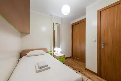 a small bedroom with a bed and a wooden door at GuestReady - Amaryllis Apartment in Porto