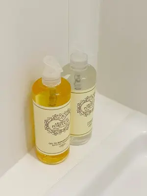 two bottles of honey sitting on a bathroom counter at Vitral House of Art District in Porto