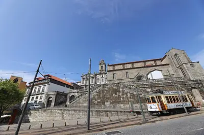 a group of people sitting on the banks of a river with a bridge at FLH Porto Cozy Studio in Porto