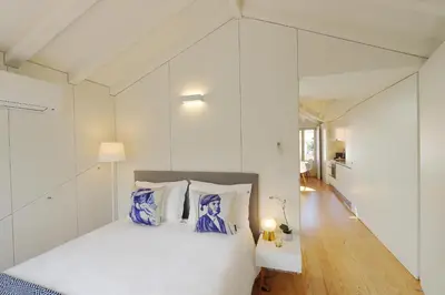 a bedroom with a bed with blue and white pillows at HM - Flores Skylight in Porto