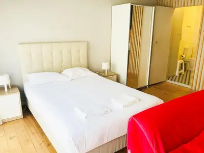 a bedroom with a large white bed with two towels on it at Bolhão Studio in Porto