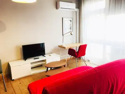 a living room with a red couch and a tv at Bolhão Studio in Porto