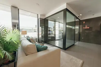 a living room with a couch and glass walls at ABC Hotel Porto - Boavista in Porto