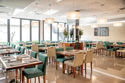 a dining room with tables and chairs and windows at ABC Hotel Porto - Boavista in Porto
