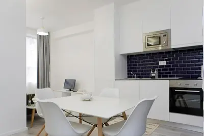 a white dining room with a white table and chairs at My Modern Homey at Porto in Porto