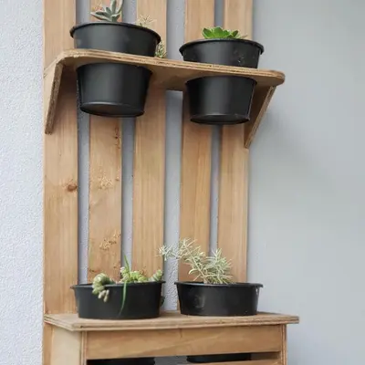 a wooden shelf with potted plants on it at À Francos Metro in Porto