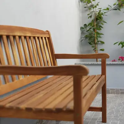 a wooden bench sitting next to a wall with plants at À Francos Metro in Porto