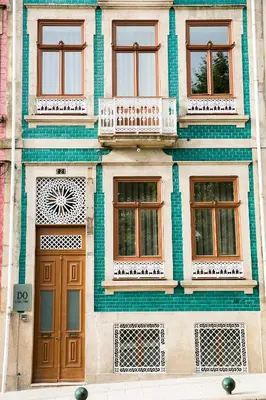 a building with brown doors and green tile at BO - Álvares Cabral GuestHouse in Porto